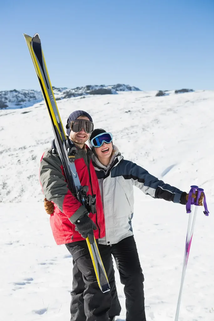 cheerful-couple-with-ski-boards-snow